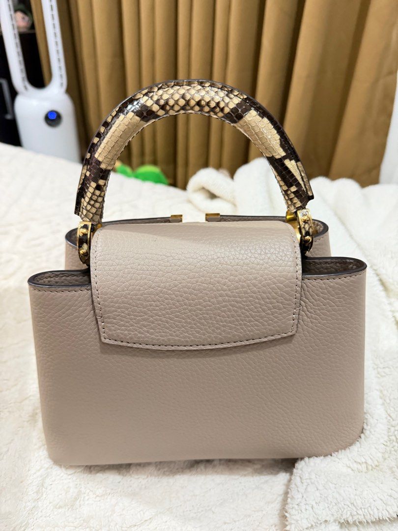 Louis Vuitton Capucines Mini Handbag (Category: Luxury Bags & Wallets) located in Manila. Submitted by luxurychicc (Listing ID 1406313708, Image 2). Description: - Authentic Louis Vuitton Capucines Mini - Neutral color - Textured leather body - Snakeskin design handle - Iconic LV logo - Perfect for any occasion Complete inclusuon with certificate from DENR.