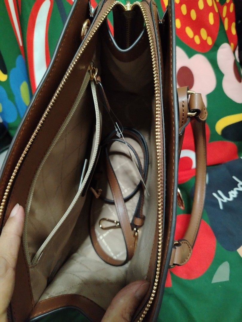 Michael Kors Brown Handbag (Category: Luxury Bags & Wallets) located in Las Pinas. Submitted by ecarg2072 (Listing ID 1406613855, Image 2). Description: - Authentic Michael Kors handbag - Brown MK logo pattern - Gold and bronze stripe detail - Detachable strap included - Features interior pockets - Top handle design - Gold zipper closure - Brand new with tag - Comes in original packaging.