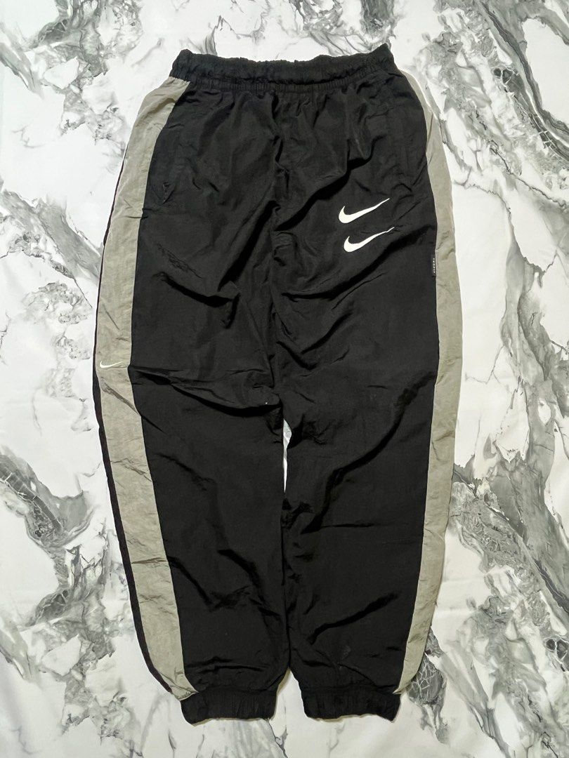 Nike Double Swoosh Track Pants - Black (Category: Joggers) located in Caloocan City. Submitted by yungbluhh (Listing ID 1406528742, Image 1). Description: - Black Nike track pants with grey side panels - Features Nike double swoosh logo on front - Smaller Nike logo on back - Elastic waistband and cuffs - Size: Small.