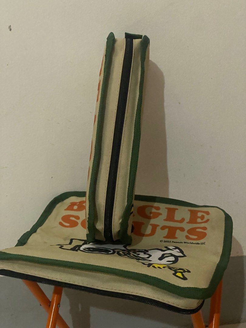 Peanuts Beagle Scouts Folding Stool (Category: Chairs) located in Davao. Submitted by hoowans_surplus (Listing ID 1406597957, Image 2). Description: - Snoopy Beagle Scouts design - Orange metal frame - Square beige seat with green border - Features the Beagle Scouts logo - Zippered edge on seat - Folds for easy storage and transport.
