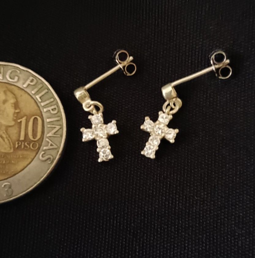 100% Legit Genuine 925 Silver Cross Hanging Earrings with white stones (Category: Earrings) located in Manila. Submitted by mhar_declutter (Listing ID 1406517354, Image 1). Description: - Elegant cross stud earrings - Features a dangling cross design - Sparkling accents - 925 Silver Earring .