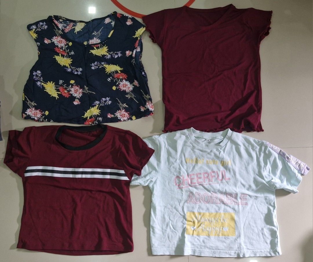 Assorted Tops - Floral, Maroon, and White (Category: Babies & Kids Fashion) located in Malolos. Submitted by prelovedclothes_stuff (Listing ID 1406747908, Image 1). Description: Collection of assorted tops in various colors and styles. Includes a navy blue floral top, two maroon tops, and a white top with a graphic print. The tops have different necklines and sleeve lengths. Perfect for casual wear. Available in multiple sizes. Please inquire for