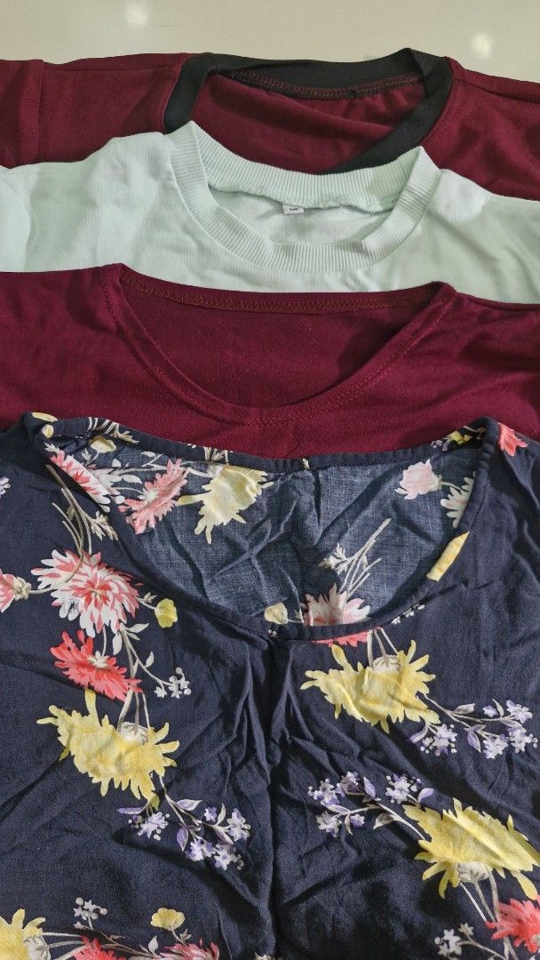 Assorted Tops - Floral, Maroon, and White (Category: Babies & Kids Fashion) located in Malolos. Submitted by prelovedclothes_stuff (Listing ID 1406747908, Image 2). Description: Collection of assorted tops in various colors and styles. Includes a navy blue floral top, two maroon tops, and a white top with a graphic print. The tops have different necklines and sleeve lengths. Perfect for casual wear. Available in multiple sizes. Please inquire for