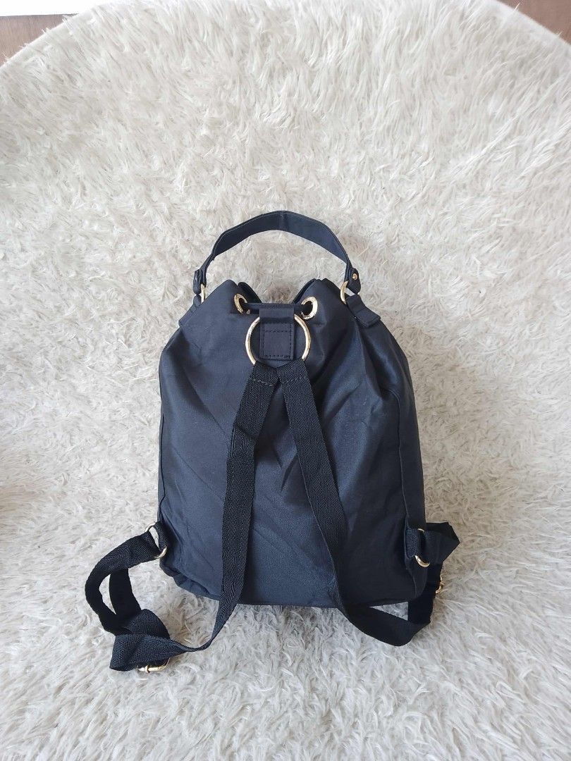 Chanel Drawstring Backpack (Category: Luxury Bags & Wallets) located in Manila. Submitted by youngforest-2089 (Listing ID 1406776596, Image 2). Description: Black drawstring backpack with gold-tone hardware. Features a top handle and adjustable shoulder straps. The interior includes a zippered pocket and a Chanel label indicating 'Made in Italy'. The exterior displays the Chanel logo. The bag has a drawstring closure and gold-tone eyelets..