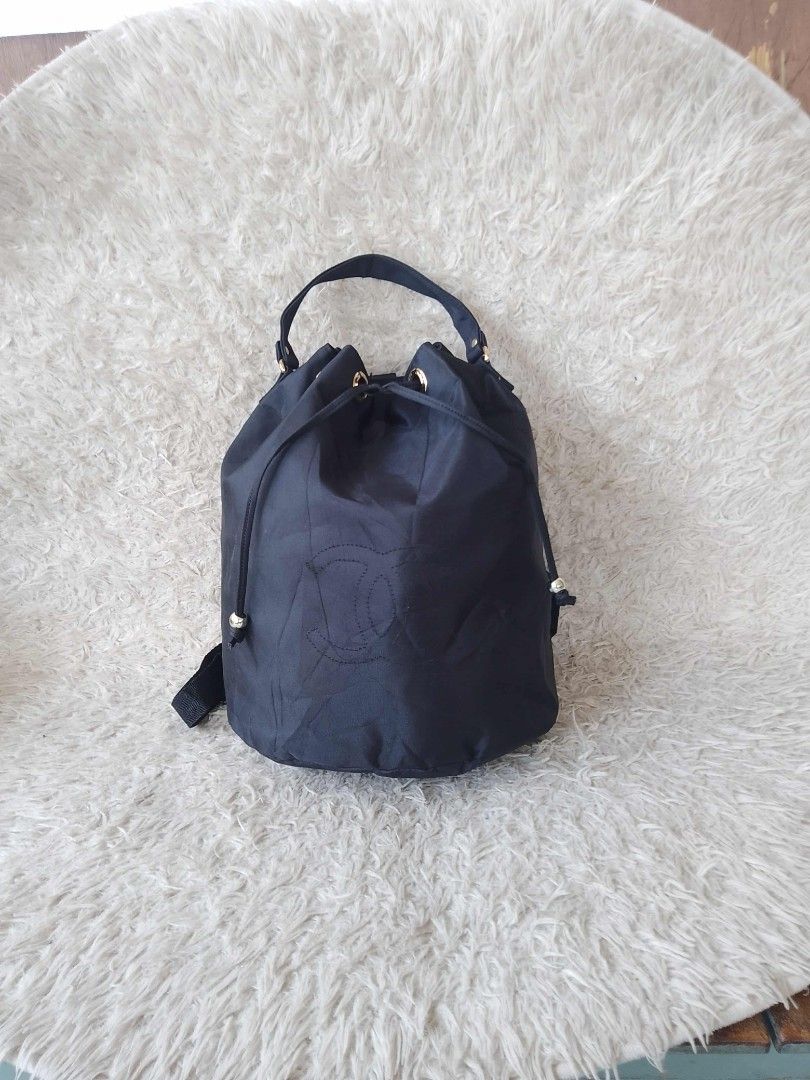 Chanel Drawstring Backpack (Category: Luxury Bags & Wallets) located in Manila. Submitted by youngforest-2089 (Listing ID 1406776596, Image 1). Description: Black drawstring backpack with gold-tone hardware. Features a top handle and adjustable shoulder straps. The interior includes a zippered pocket and a Chanel label indicating 'Made in Italy'. The exterior displays the Chanel logo. The bag has a drawstring closure and gold-tone eyelets..