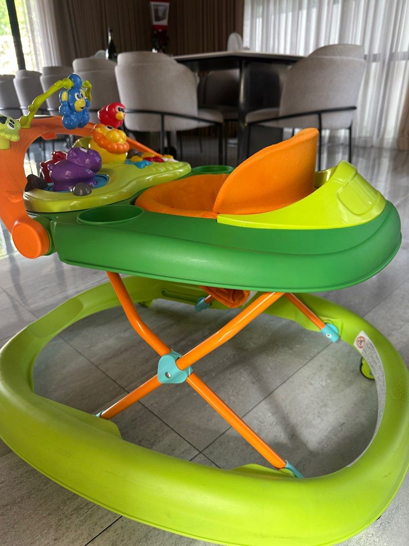 Chicco Baby Walker (Category: Infant Playtime) located in Angeles City. Submitted by shopmycloset_101 (Listing ID 1406648747, Image 3). Description: - Chicco baby walker - Bright green and orange design - Padded seat for comfort - Includes cup holders - Features an activity center with toys - Helps babies learn to walk.