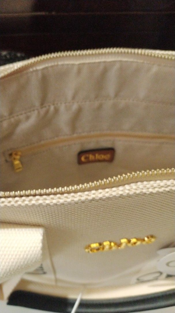 Chloe Woody Tote Bag (Category: Luxury Bags & Wallets) located in Bacoor. Submitted by anag729 (Listing ID 1406775269, Image 3). Description: - Chloe Woody tote bag - Beige canvas body - Black logo straps - Zip closure - Interior pocket - Gold-tone hardware - Includes box, tags - Spacious interior - Perfect for everyday use.