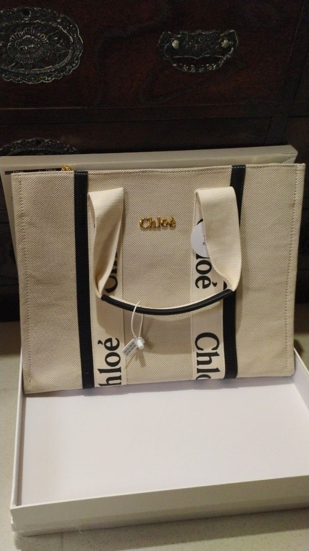 Chloe Woody Tote Bag (Category: Luxury Bags & Wallets) located in Bacoor. Submitted by anag729 (Listing ID 1406775269, Image 1). Description: - Chloe Woody tote bag - Beige canvas body - Black logo straps - Zip closure - Interior pocket - Gold-tone hardware - Includes box, tags - Spacious interior - Perfect for everyday use.