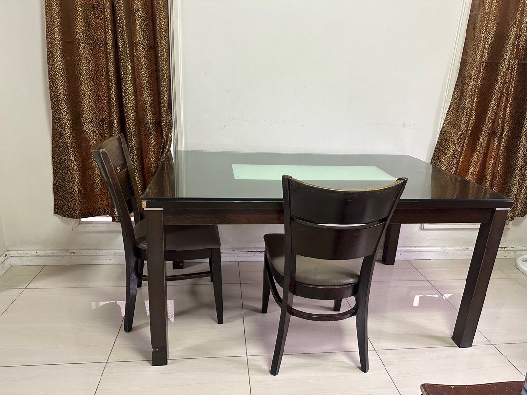 Dining Table with 2 Chairs (Category: Tables & Sets) located in Cainta. Submitted by kath_pl (Listing ID 1406768560, Image 1). Description: - Dark wood dining table with glass top - Light-colored center panel - Includes two matching chairs with gray upholstered seats - Table shows wear on corners - Perfect for small dining areas or kitchens - Chairs and bench offer comfortable seating - 6 seaters dining table.
