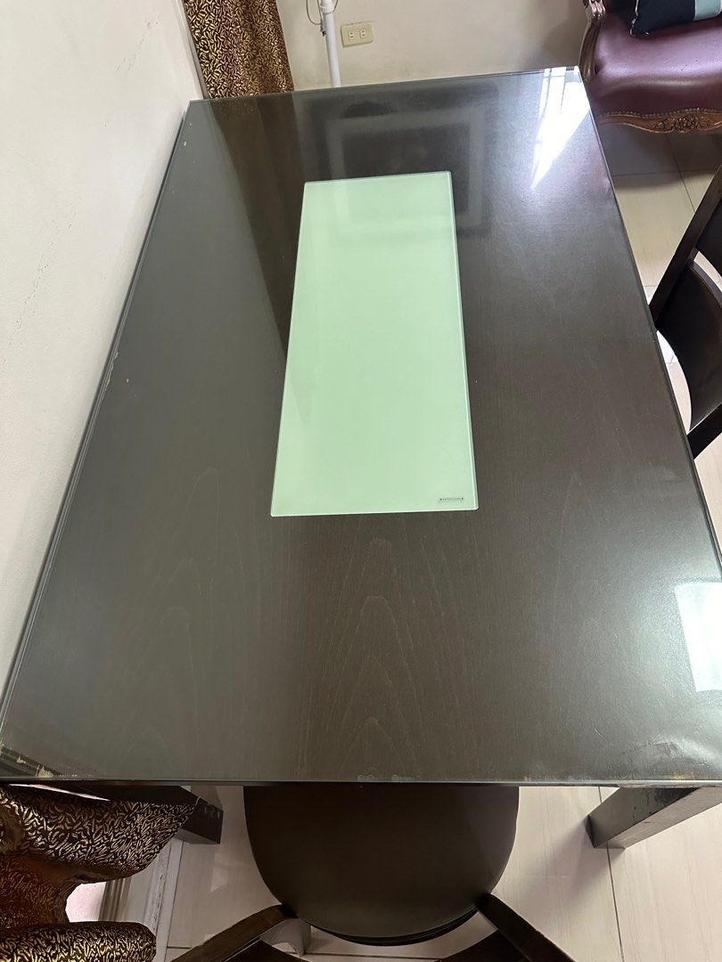 Dining Table with 2 Chairs (Category: Tables & Sets) located in Cainta. Submitted by kath_pl (Listing ID 1406768560, Image 3). Description: - Dark wood dining table with glass top - Light-colored center panel - Includes two matching chairs with gray upholstered seats - Table shows wear on corners - Perfect for small dining areas or kitchens - Chairs and bench offer comfortable seating - 6 seaters dining table.