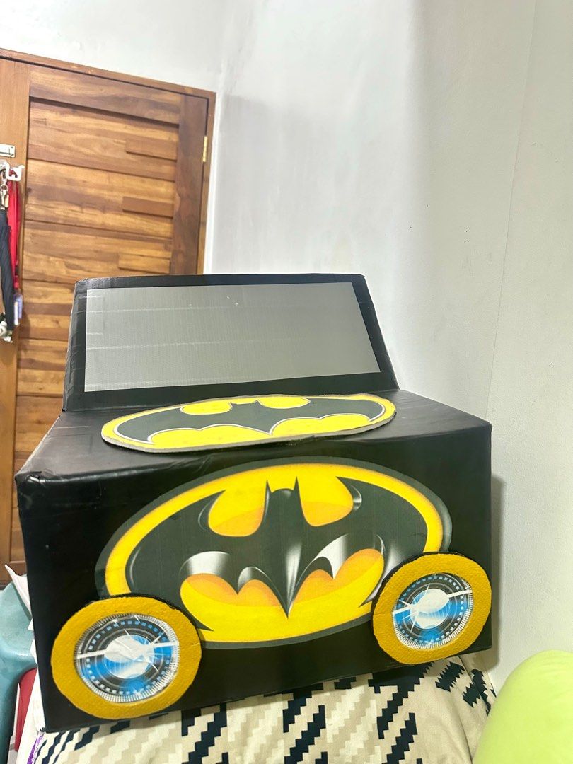 DIY Batman Car Costume (Category: Babies & Kids Fashion) located in Manila. Submitted by AngelResty (Listing ID 1406701984, Image 2). Description: - Handmade Batman car costume - Designed for kids - Features a black car design - Batman logos on wheels and body - Includes a carrying strap - Ideal for dress-up, parties, and Halloween - Made of cardboard.