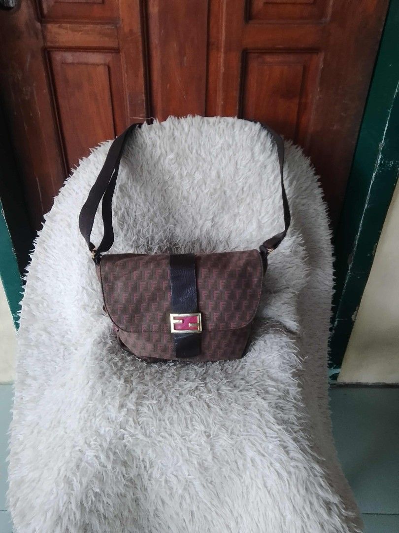 Fendi Shoulder Bag (Category: Luxury Bags & Wallets) located in Manila. Submitted by youngforest-2089 (Listing ID 1406768664, Image 1). Description: - Authentic Fendi shoulder bag - Brown with repeating pattern - Flap closure with gold-tone buckle - Long shoulder strap - Zipper closure - Interior pocket - Fendi logo visible - Made of textured material.