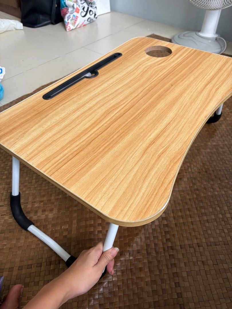 Foldable Laptop Table (Category: Tables & Sets) located in Manila. Submitted by pinpoints (Listing ID 1406684527, Image 1). Description: - Foldable laptop table - Wood-grain finish - Includes a slot for phone or tablet - White legs with black accents - Portable and easy to store .
