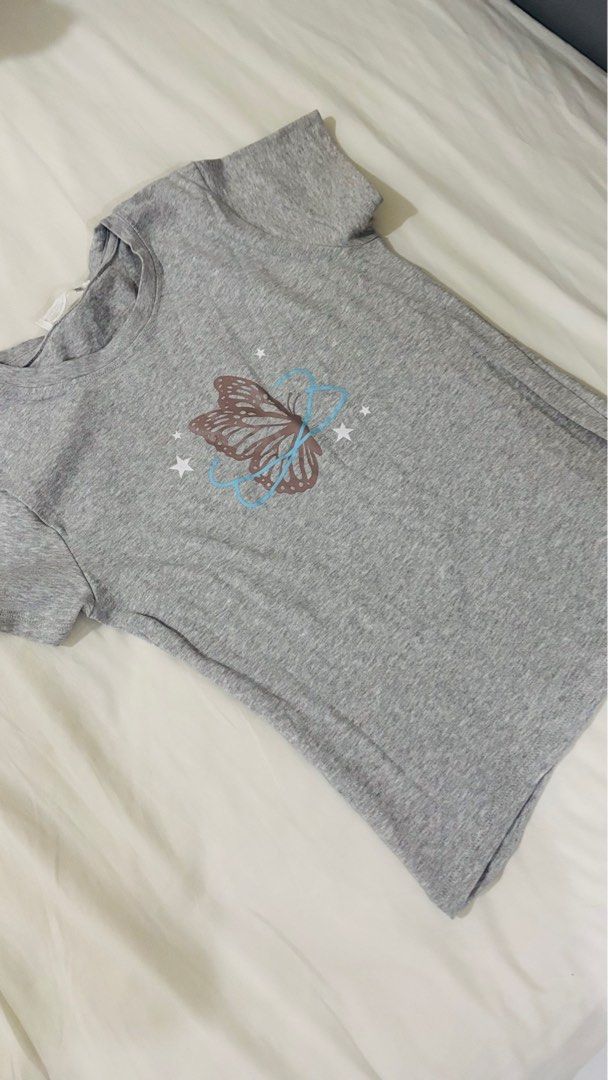 Graphic T-shirts - White, Gray, Brown (Category: Shirts) located in Las Pinas. Submitted by katb86 (Listing ID 1406728411, Image 2). Description: - Set of three graphic t-shirts. - Includes: - White tee with red "No Backstage Passes" design. - Gray tee with butterfly graphic. - Brown ribbed tank top with wing design (tag still attached)..