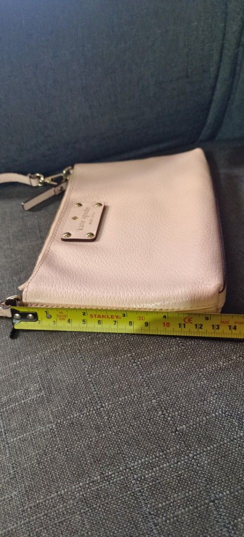 Kate Spade New York Handbag (Category: Luxury Bags & Wallets) located in Muntinlupa City. Submitted by amara211629 (Listing ID 1406712374, Image 3). Description: Kate Spade handbag features a light pink exterior with a top handle and a zipper closure. The interior has a fabric lining with the Kate Spade New York logo. The bag has a small rectangular shape. The bag measures approximately 20cm in length and 13cm in height. It has a detachable strap