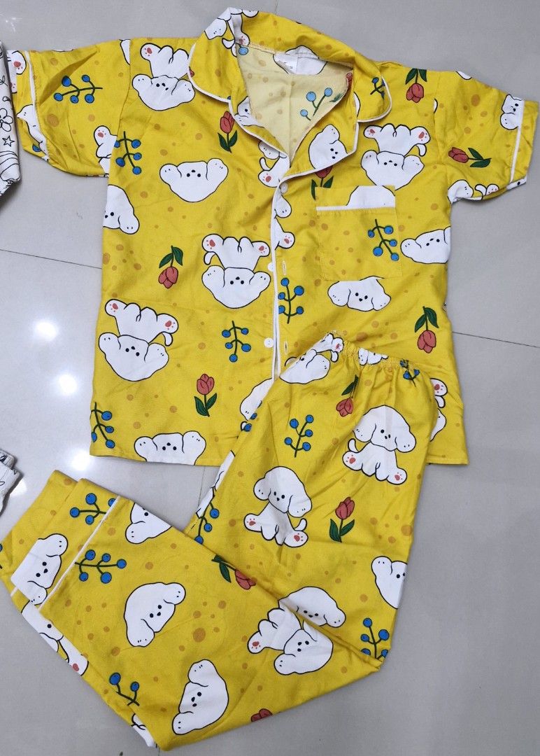 TAKE ALL Kids' Pajama Set - Cartoon Print (Category: Babies & Kids Fashion) located in Malolos. Submitted by prelovedclothes_stuff (Listing ID 1406770659, Image 3). Description: - Adorable kids' pajama sets. - Available sets: - White set: Long-sleeved top and pants. - Yellow set: Short-sleeved button-up top and pants with a cute dog print. - Designed for comfort and style. - Perfect for a cozy night's sleep. 5to7yo.