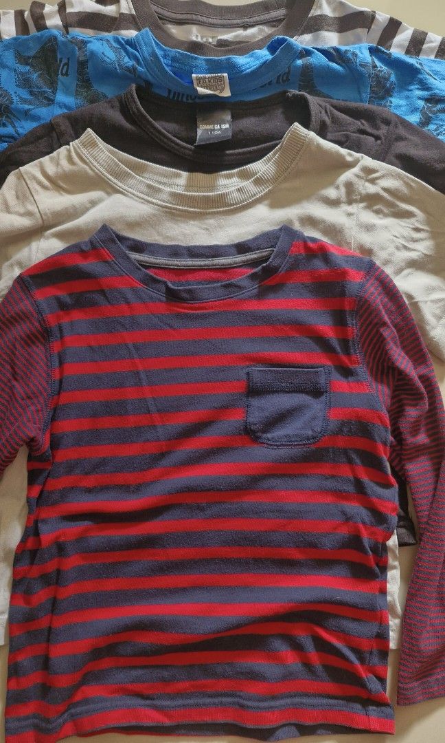 Kids' T-shirts - Assorted Designs (Category: Babies & Kids Fashion) located in Malolos. Submitted by prelovedclothes_stuff (Listing ID 1406746121, Image 2). Description: Collection of kids' t-shirts in various designs and colors. Includes a striped shirt, a blue dinosaur print shirt, a gray shirt with a pocket, a red striped shirt, and a black shirt with a graphic. Perfect for everyday wear. Sizes may vary. Please inquire for specific details..