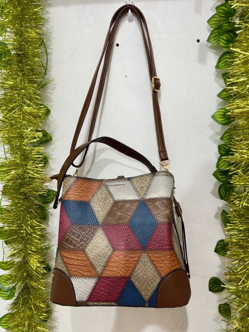 Multi-color Patchwork Bucket Bag with adjustable Shoulder Strap multiple compartment (Category: Shoulder Bags) located in Makati City. Submitted by hello_ph (Listing ID 1406654727, Image 2). Description: - Unique patchwork design - Brown base and trim - Matching shoulder strap - Top handle - Interior zippered pocket - Versatile for everyday use.