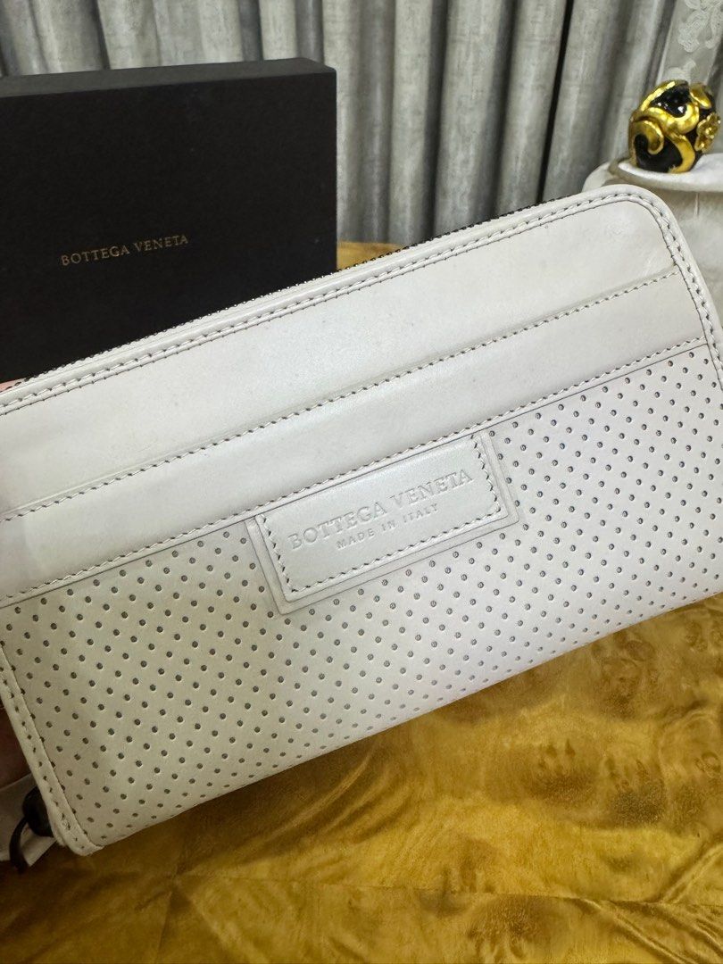 Bottega Veneta White Perforated Leather Zip Wallet (Category: Luxury Bags & Wallets) located in Makati City. Submitted by happyprelovedph (Listing ID 1406882829, Image 2). Description: - Authentic Bottega Veneta zip wallet - White perforated leather - Zip closure - Multiple interior compartments - Wrist strap - Includes original box, dust bag, and authenticity cards - Made in Italy - Never Been Used.