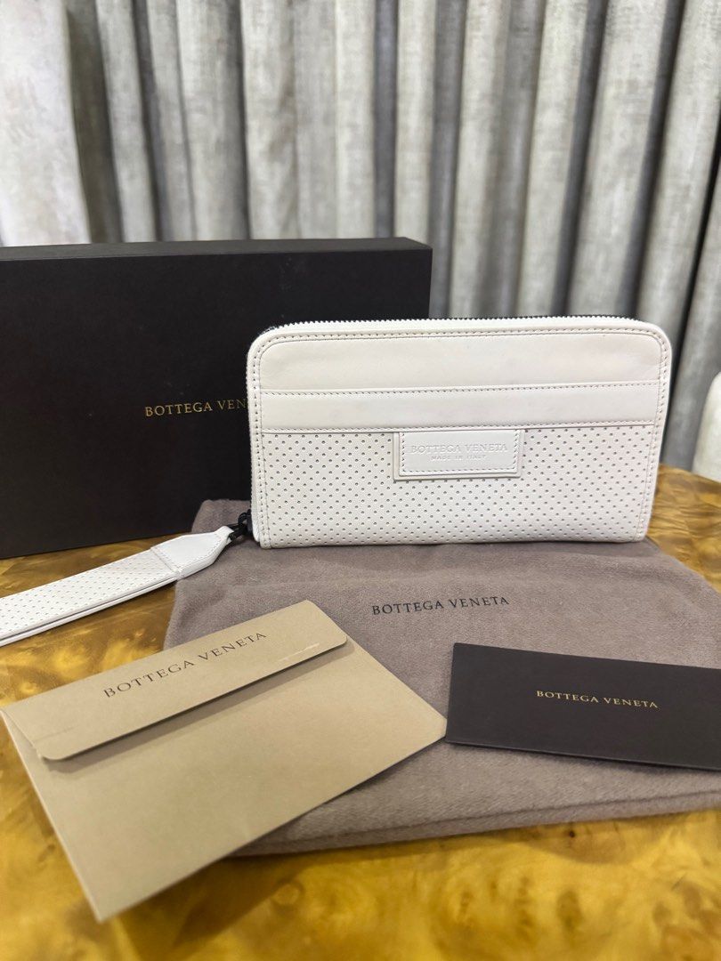 Bottega Veneta White Perforated Leather Zip Wallet (Category: Luxury Bags & Wallets) located in Makati City. Submitted by happyprelovedph (Listing ID 1406882829, Image 1). Description: - Authentic Bottega Veneta zip wallet - White perforated leather - Zip closure - Multiple interior compartments - Wrist strap - Includes original box, dust bag, and authenticity cards - Made in Italy - Never Been Used.