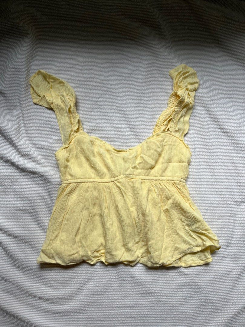 Hollister Yellow Top XS （分類：T-shirt）位於 Hong Kong。 由 coolbeans88 提交（商品編號 1406906582，圖片 2）。簡介： Baby yellow tank top Yellow top from Hollister features a square neckline and ruffled straps. It has a fitted bodice with a peplum hem. The top is size XS. The fabric has a textured appearance. It is a light yellow color.。