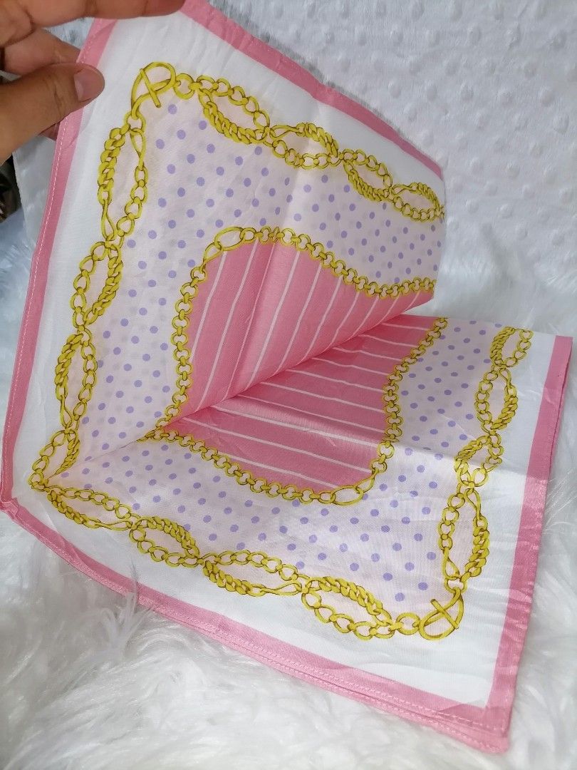 Mario Valentino Handkerchief Set (Category: Handkerchief & Pocket Squares) located in Butuan. Submitted by az-branded.items (Listing ID 1406936844, Image 3). Description: - Set of two Mario Valentino handkerchiefs. - Handkerchief 1: Pink and white design with gold chain accents. - Handkerchief 2: Floral pattern with pink roses and green leaves. - Both handkerchiefs feature the Mario Valentino logo. -Semi bandana & large sizes.
