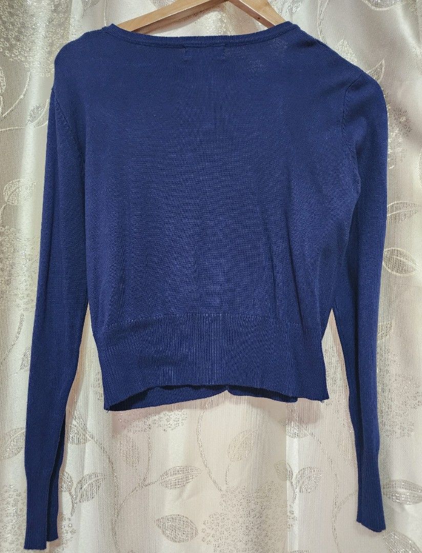 Bayo Navy Blue Cardigan (Category: Coats, Jackets and Outerwear) located in Cabuyao City. Submitted by krzslv (Listing ID 1402067081, Image 2). Description: Navy blue cardigan from Bayo. It features a diamond pattern on the front and a button-up closure. The cardigan has long sleeves and a round neckline. It is a medium size. The back is plain navy blue. The tag is visible in the image..
