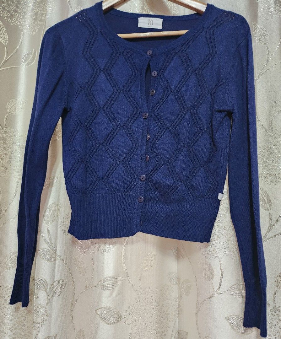 Bayo Navy Blue Cardigan (Category: Coats, Jackets and Outerwear) located in Cabuyao City. Submitted by krzslv (Listing ID 1402067081, Image 1). Description: Navy blue cardigan from Bayo. It features a diamond pattern on the front and a button-up closure. The cardigan has long sleeves and a round neckline. It is a medium size. The back is plain navy blue. The tag is visible in the image..