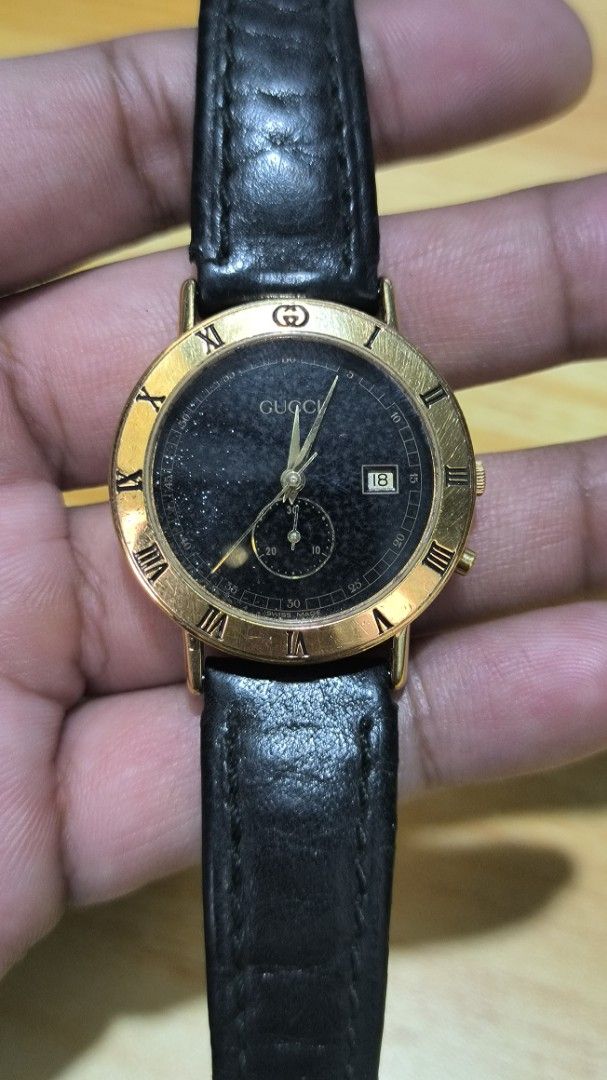 Gucci Gold-Tone Watch with Black Dial (Category: Women's Watches) located in Taguig. Submitted by tester1x (Listing ID 1401946668, Image 1). Description: - Gucci watch with gold-tone case - Sleek black dial - Roman numeral hour markers - Date display - Black leather strap - Gold-tone buckle - Gucci logo and model number 3600J engraved on the back - Features a small subdial.