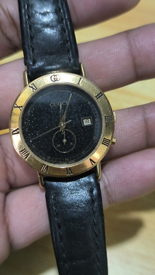 Gucci Gold-Tone Watch with Black Dial (Category: Women's Watches) located in Taguig. Submitted by tester1x (Listing ID 1401946668, Image 2). Description: - Gucci watch with gold-tone case - Sleek black dial - Roman numeral hour markers - Date display - Black leather strap - Gold-tone buckle - Gucci logo and model number 3600J engraved on the back - Features a small subdial.