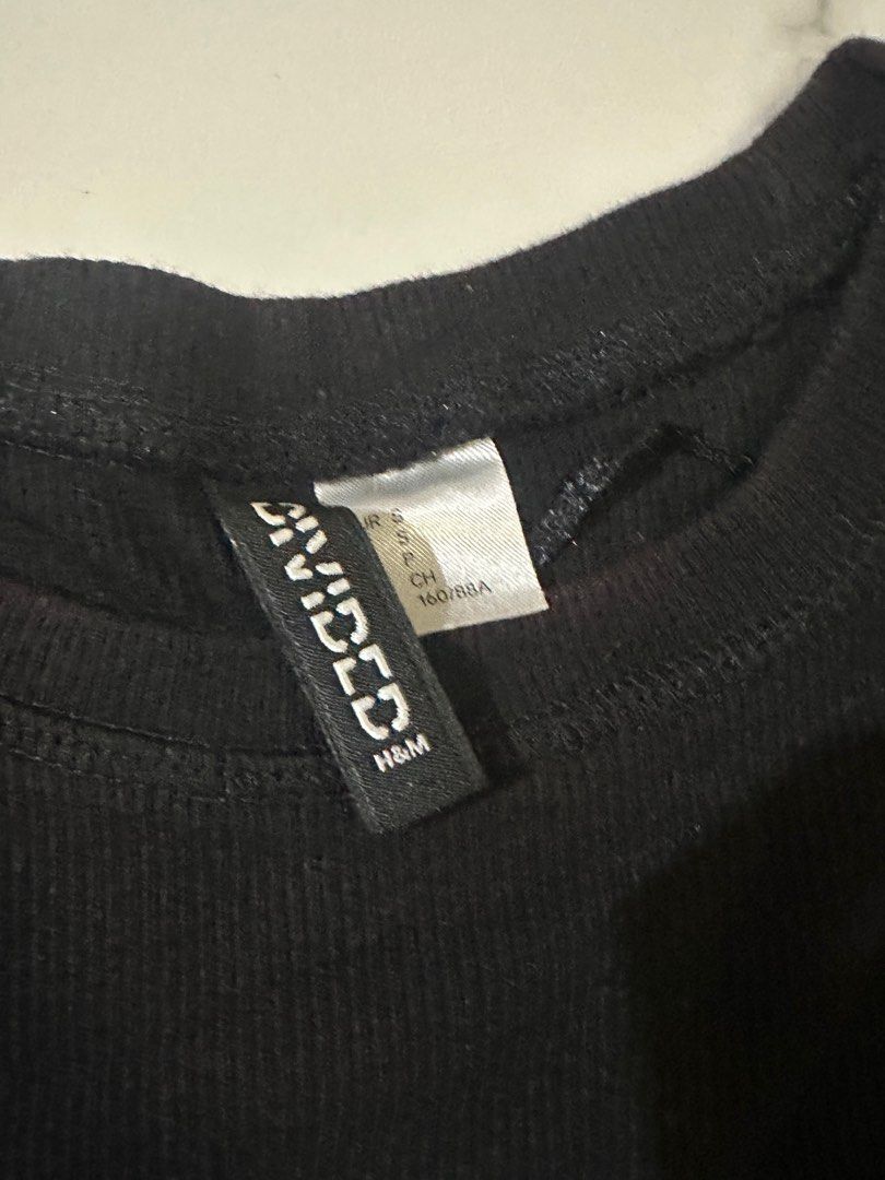 H&M Divided Black Ribbed T-shirt (Category: Shirts) located in Manila. Submitted by cchaiprincess (Listing ID 1401948464, Image 2). Description: - H&M Divided black ribbed t-shirt - Size: S - Features a graphic design - Ribbed material - In good condition.