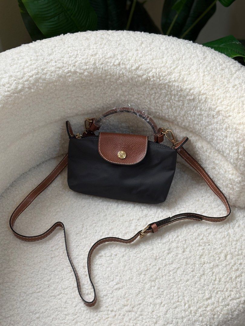 Longchamp Le Pliage Mini (Category: Luxury Bags & Wallets) located in Manila. Submitted by blaireblissph (Listing ID 1402005705, Image 1). Description: Black nylon Longchamp Le Pliage shoulder bag with brown leather trim and a detachable shoulder strap. Features a top handle and a flap closure with a gold-tone snap. Perfect for everyday use or travel..