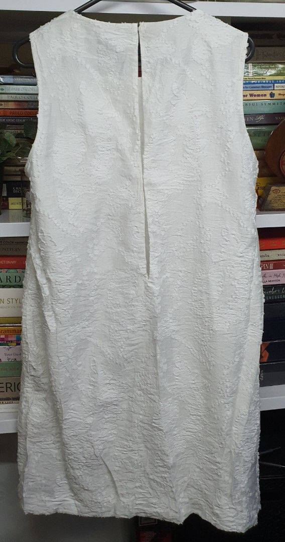 Mango White Sleeveless Dress (Category: Dresses) located in Manila. Submitted by apoltree (Listing ID 1401953496, Image 2). Description: White sleeveless dress from Mango. Features a textured fabric and a simple, elegant design. The dress has a button closure at the back. The label indicates an EUR XS, USA 2, MEX ECH size. Perfect for a casual or semi-formal occasion. Unused but washed RFS - decluttering.