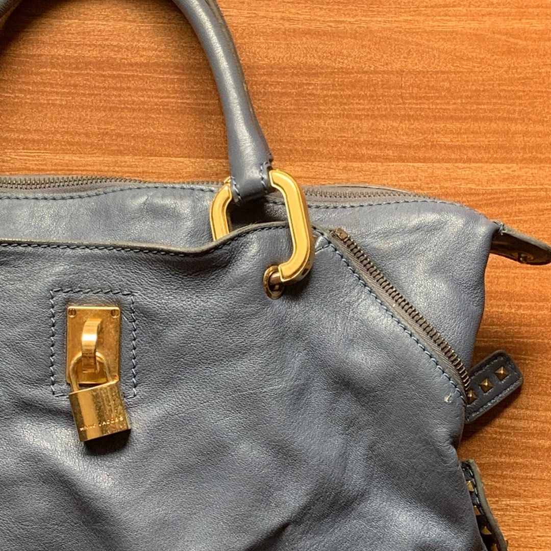 Marc Jacobs Leather Handbag (Category: Luxury Bags & Wallets) located in Cavite. Submitted by pickednthrift64 (Listing ID 1401924316, Image 2). Description: - Authentic Marc Jacobs handbag - Blue leather exterior - Gold-tone hardware - Top handle - Zip closure - Padlock detail - RIRI zipper - Visible interior lining - Some wear on handle - Spacious interior.