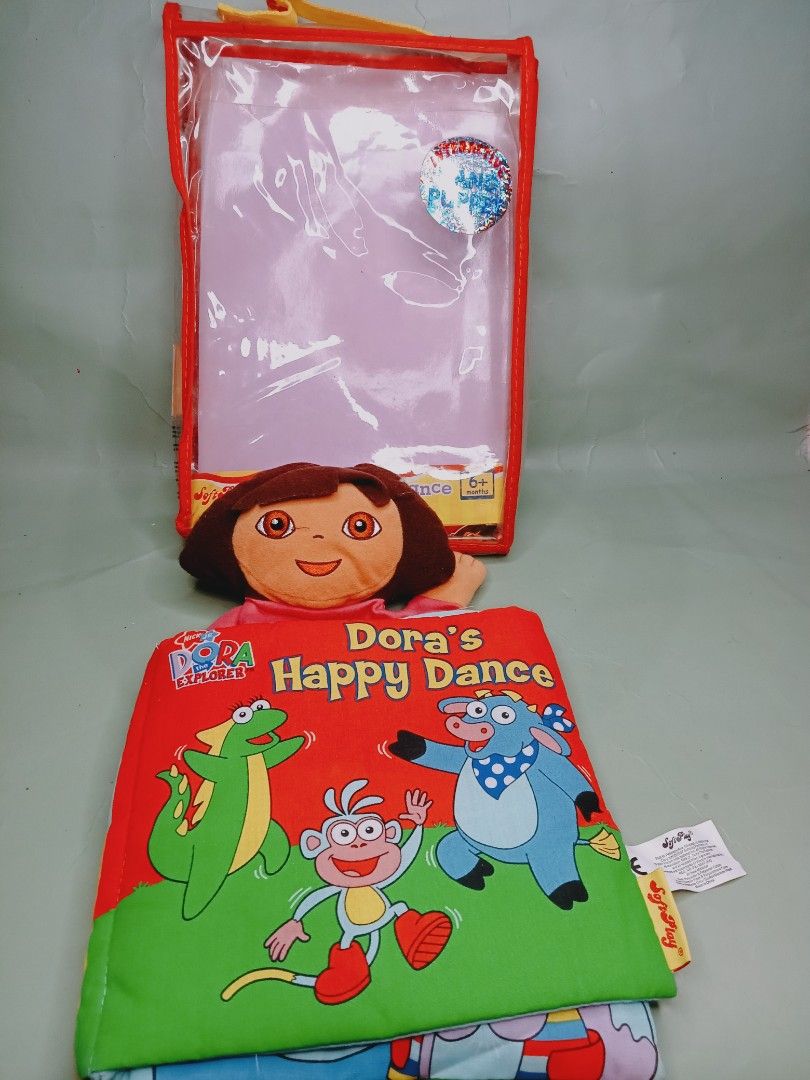 Nickelodeon Dora the Explorer Dora's Happy Dance Book (Category: Children's Books) located in Rosario. Submitted by elysedeclutter (Listing ID 1401974437, Image 1). Description: - Dora the Explorer "Dora's Happy Dance" book - Includes a Dora plush doll puppet - Comes with a clear plastic case - Features colorful illustrations - Perfect for kids.