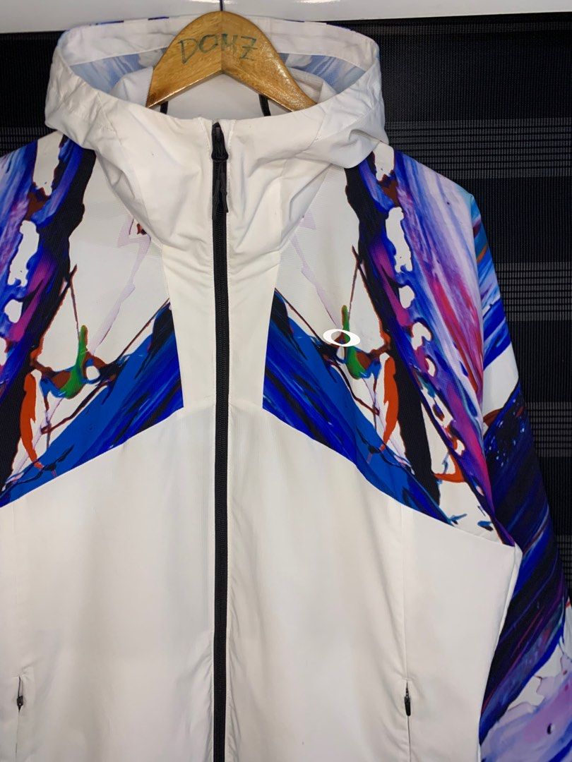 Oakley Meguru Yamaguchi Jacket (Category: Coats, Jackets and Outerwear) located in Polomolok. Submitted by domingthriftclothes (Listing ID 1402046211, Image 2). Description: - Oakley jacket, size XL - Unique artistic design with colorful abstract patterns - White base with patterns on sleeves and upper chest - Features a hood and full-length zipper - Two side pockets - Packable design - Collaboration with Meguru Yamaguchi.