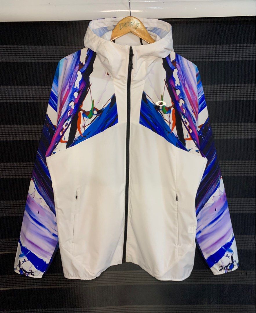 Oakley Meguru Yamaguchi Jacket (Category: Coats, Jackets and Outerwear) located in Polomolok. Submitted by domingthriftclothes (Listing ID 1402046211, Image 1). Description: - Oakley jacket, size XL - Unique artistic design with colorful abstract patterns - White base with patterns on sleeves and upper chest - Features a hood and full-length zipper - Two side pockets - Packable design - Collaboration with Meguru Yamaguchi.