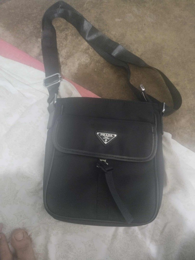 Prada Black Messenger Bag (Category: Luxury Bags & Wallets) located in Alaminos. Submitted by osaj55756 (Listing ID 1401919049, Image 1). Description: - Authentic Prada messenger bag - Classic black nylon material - Features the Prada logo - Adjustable shoulder strap for comfort - Secure zipper closure.