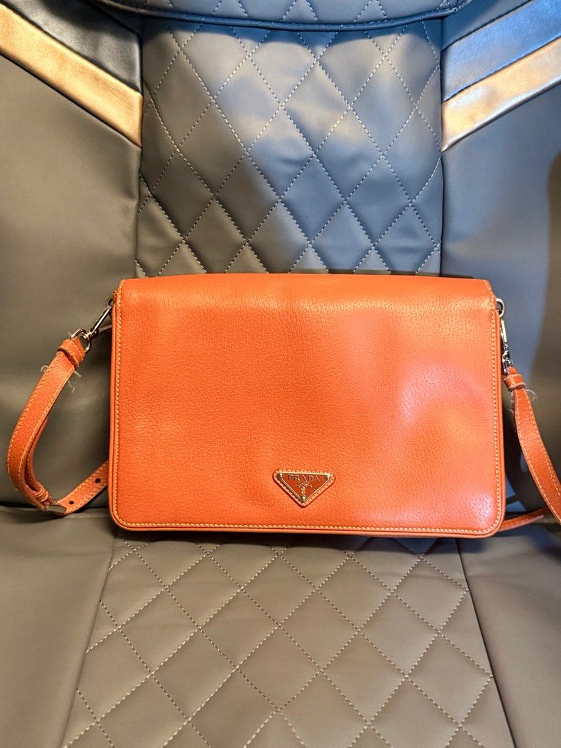 Prada flap Bag (Category: Luxury Bags & Wallets) located in Makati City. Submitted by martinoloco (Listing ID 1401924968, Image 2). Description: - Prada shoulder bag - Orange leather - Flap closure with Prada logo - Adjustable long strap - White stitching details - Small Prada logo at the back - Classic and stylish design .