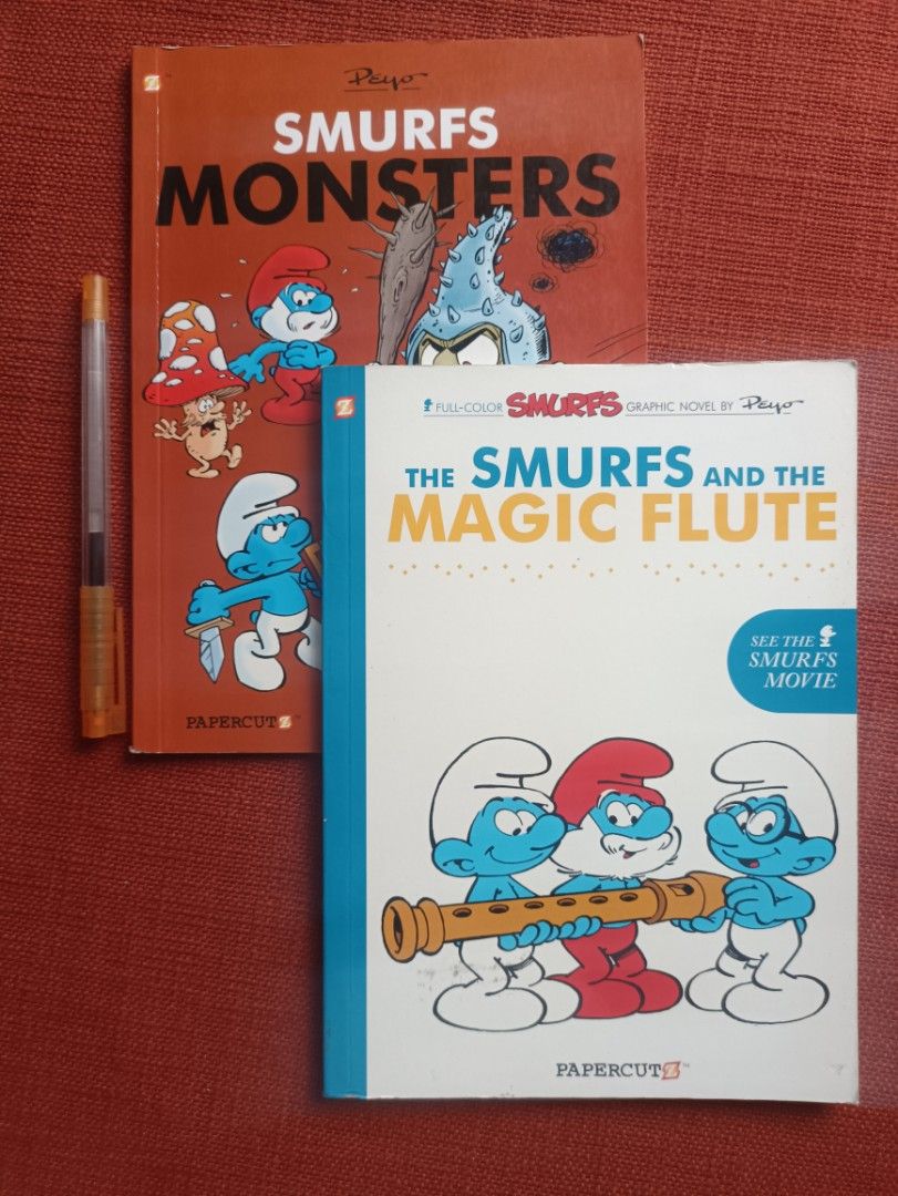 Smurfs Graphic Novels Bundle- Monsters & Magic Flute (Category: Comics & Manga) located in Manila. Submitted by krishna_ayanami (Listing ID 1402045688, Image 1). Description: Two Smurfs graphic novels: "Smurfs Monsters" and "The Smurfs and the Magic Flute." Both are published by Papercutz. "The Smurfs and the Magic Flute" is a full-color graphic novel and mentions the Smurfs movie. The back of "Smurfs Monsters" says it presents the original story