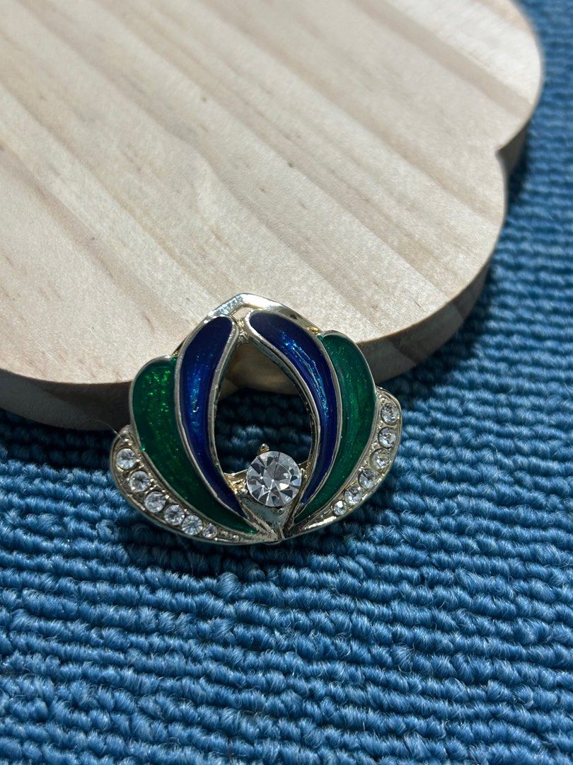 Vintage Enamel and Crystal Brooch (Category: Brooches) located in Angeles City. Submitted by zyeplus (Listing ID 1401929687, Image 1). Description: Brooch features a floral design with green and blue enamel petals. It has a central clear crystal and is accented with smaller crystals around the edges. The brooch has a silver-tone metal finish. It's a classic piece that can add a touch of elegance to any outfit. No Markings.