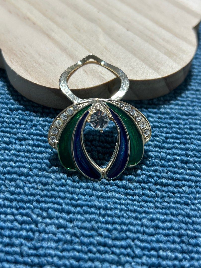 Vintage Enamel and Crystal Brooch (Category: Brooches) located in Angeles City. Submitted by zyeplus (Listing ID 1401929687, Image 2). Description: Brooch features a floral design with green and blue enamel petals. It has a central clear crystal and is accented with smaller crystals around the edges. The brooch has a silver-tone metal finish. It's a classic piece that can add a touch of elegance to any outfit. No Markings.