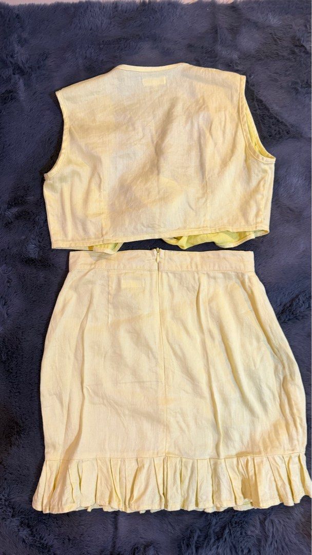 Artisanat and Handmade Morrie Coords - XS (Category: Sets or Coordinates) located in Manila. Submitted by camztorr (Listing ID 1407103135, Image 2). Description: - Artisan & Handmade co-ord set - Includes a sleeveless top with tie-front detail - Features a mini skirt with a ruffled hem - Color: Light Yellow - Size: XS - Skirt has a zipper closure.