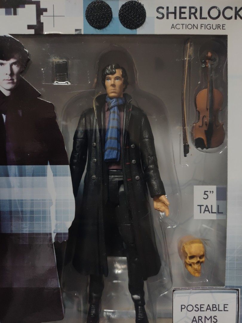 BBC Sherlock Action Figure (5") (Category: Figurines & Statues) located in Manila. Submitted by beacko (Listing ID 1407024447, Image 2). Description: Brand new BBC Sherlock Holmes action figure in the likeness of Benedict Cumberbatch. - Approximately 5 inches tall - Includes accessories: phone, violin, skull - Features poseable arms - Packaged in a box with Sherlock Holmes images and a cool 221B door with velcro closure. - Manufactured by Undergr