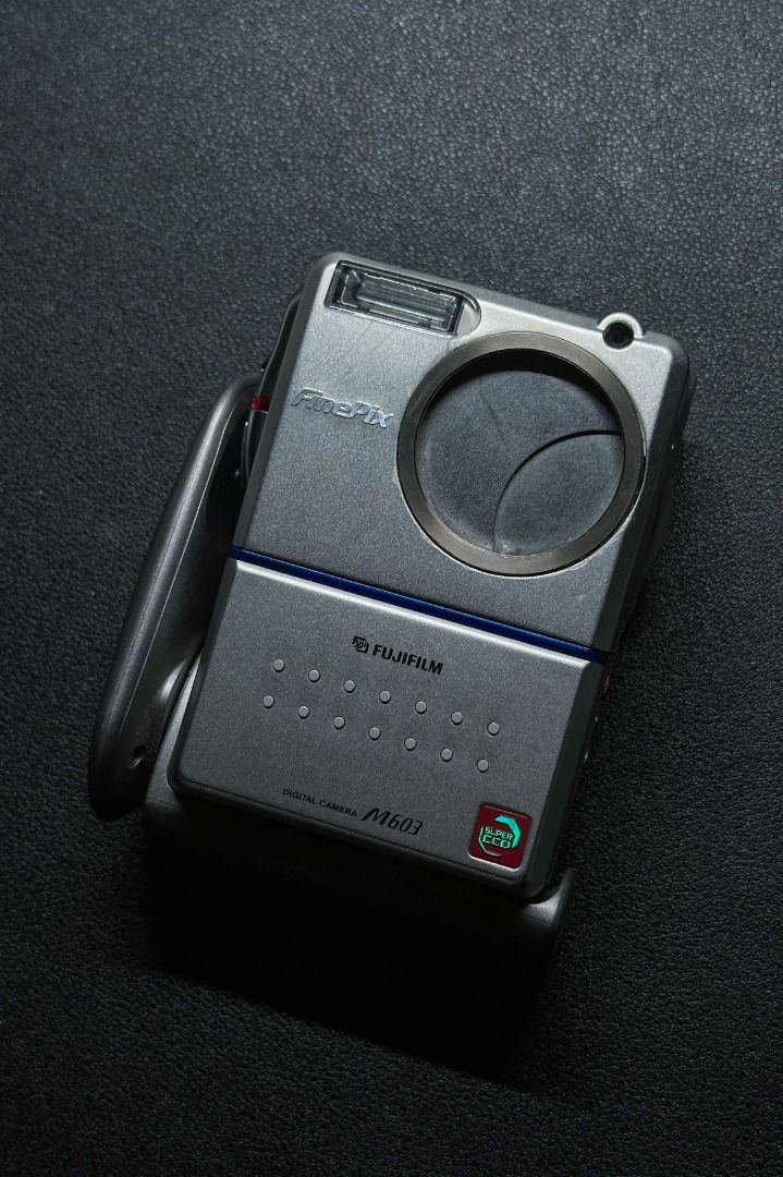 Fujifilm FinePix M603 連遮光罩 | 富士CCD機皇 （分類：相機）位於 Hong Kong。 由 auxaudio 提交（商品編號 1407179167，圖片 1）。簡介： Fujifilm FinePix M603 | 富士CCD機皇 Fujifilm FinePix M603 是一款於 2002 年推出的經典直立式數位相機，結合高品質靜態攝影與 VGA 影片錄製功能，適合喜愛輕便攜帶與多功能拍攝的用戶。 - 3.1 百萬畫素 Super CCD 感光元件：透過富士獨家技術，輸出高達 600 萬畫素影像 - VGA 影片錄製：支援 320x240 解析度，30 或 15 fps 錄影 - 2.5 吋 LCD 螢幕：大尺寸螢幕方便取景與回放，無需傳統觀景窗，輕鬆捕捉每個瞬間。 - 4.4 倍變焦鏡頭：提供靈活的構圖選擇，適合拍攝遠近景物。 - 輕巧設計：僅 210 克，尺寸 93 x 31 x 64 mm，方便隨身攜帶，時尚外型兼具實用性。 ------------