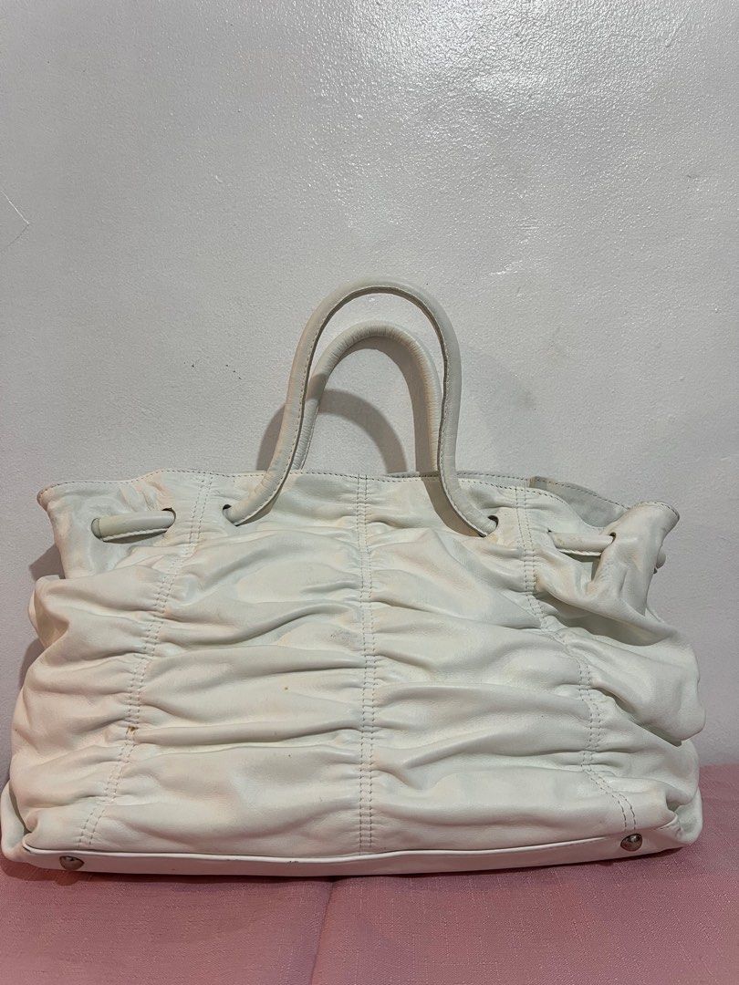 Furla White Leather Tote Bag (Category: Luxury Bags & Wallets) located in Tacloban City. Submitted by classy_luxury (Listing ID 1407127185, Image 2). Description: Sale ‼️ Sale ‼️ - Authentic Furla tote bag - White leather - Ruched design - Double top handles - Magnetic snap closure - Interior zip pocket - Furla logo - Metal feet for protection - Made in Tunisia.