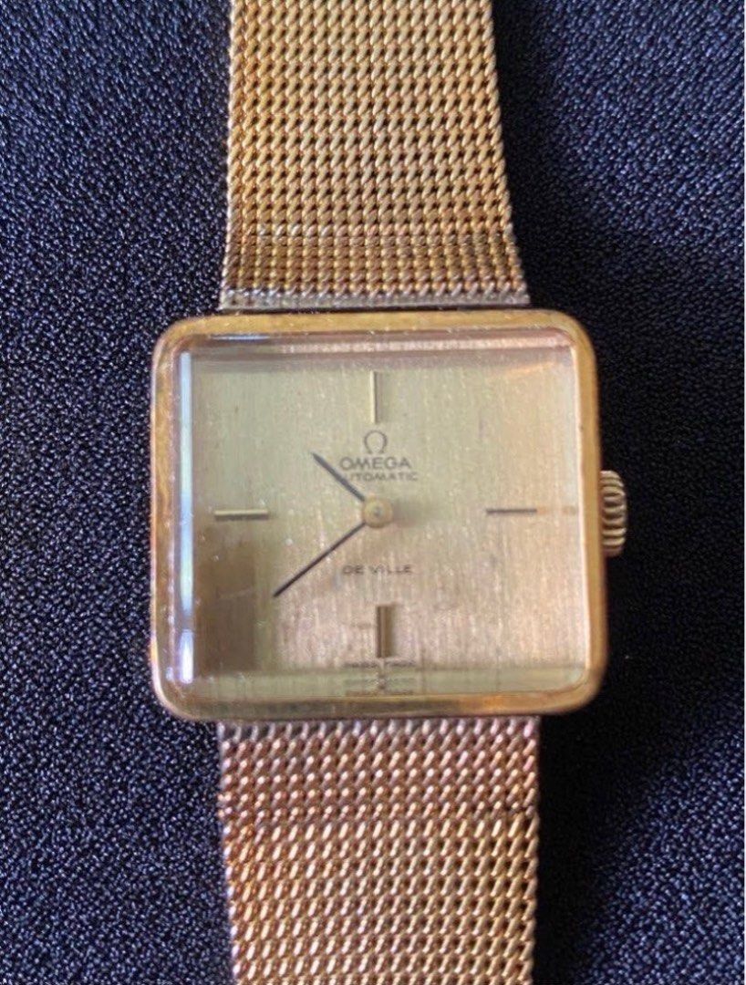 Omega De Ville Automatic Gold Watch (Category: Luxury Watches) located in Paranaque City. Submitted by bloo_berry (Listing ID 1407191152, Image 1). Description: Vintage Omega De Ville automatic watch with a gold-toned square dial and mesh strap. Features a gold-colored case and a classic design. The watch has a visible Omega logo and De Ville inscription on the dial. The watch has a crown on the side for time adjustment. Bracelet adjustable up to