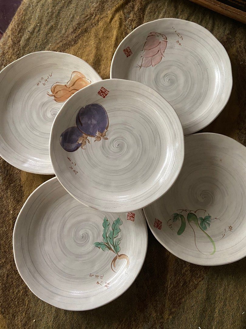 Set of 5 Decorative Ceramic Plates (Category: Dinnerware & Cutlery) located in Rizal. Submitted by mishyboo (Listing ID 1406999339, Image 2). Description: - Set of 5 ceramic plates - Features unique vegetable illustrations (eggplant, radish, etc.) - Includes calligraphy and a spiral pattern - Each plate has a distinct design - Perfect for adding art to your dining experience.