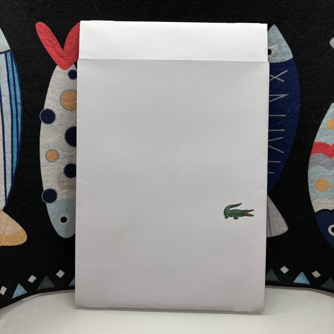 Lacoste Box (Category: Luxury Bags & Wallets) located in Manila. Submitted by urbanwear (Listing ID 1402219852, Image 1). Description: - Authentic Lacoste envelope - Sealed condition - Features the Lacoste crocodile logo - Made of a textured material.