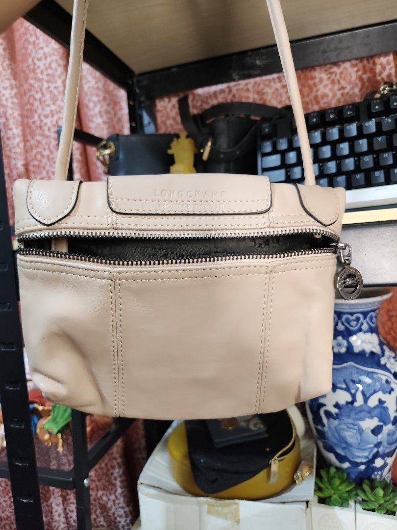 Longchamp Shoulder Bag (Category: Luxury Bags & Wallets) located in Baguio. Submitted by alonasteph (Listing ID 1402113973, Image 2). Description: - Longchamp shoulder bag - Color: Light beige - Closure: Flap with snap button and zip - Shoulder strap included - Interior lining with repeating pattern - Small logo detail.